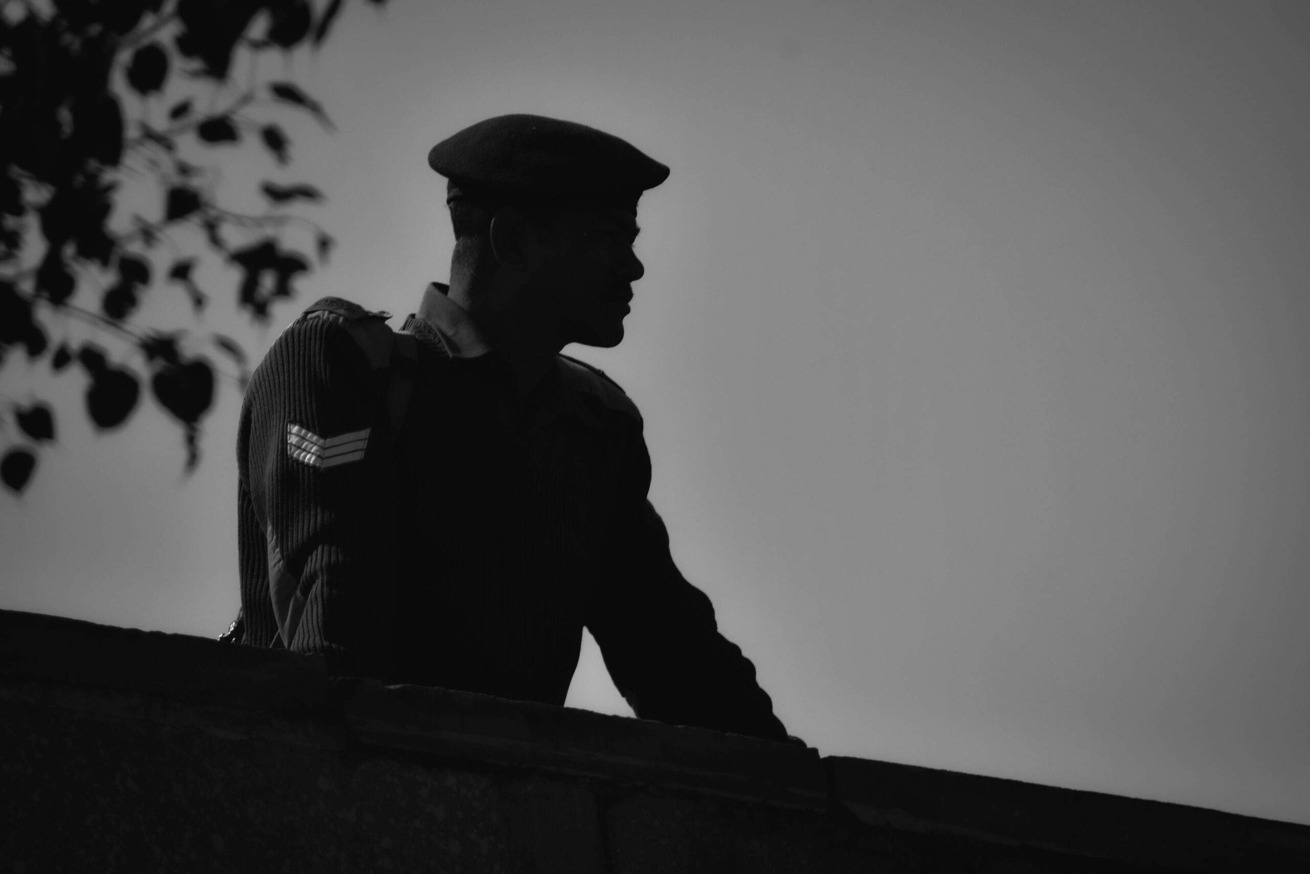 Services Black and white silhouette of a soldier in uniform against the sky in Agra, India.