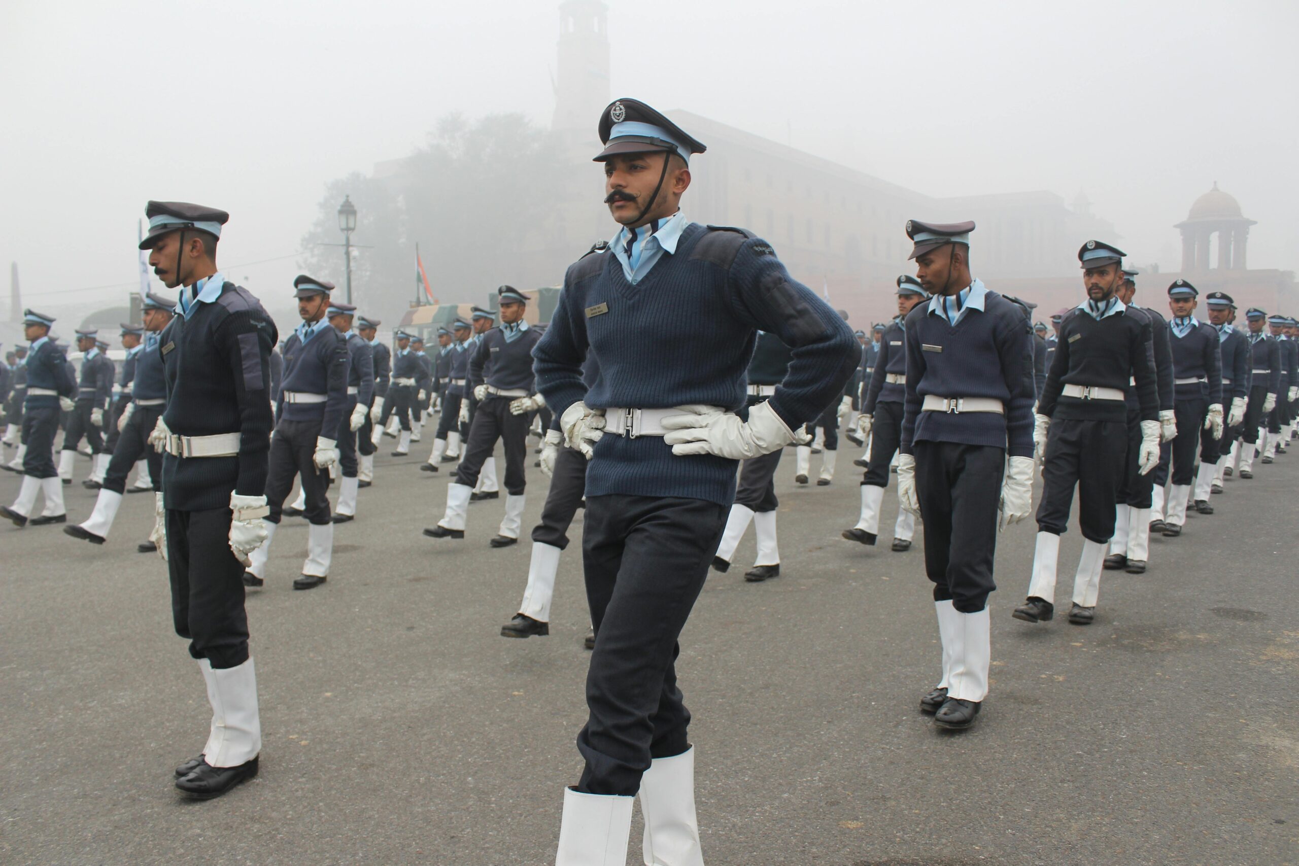 HOME Indian military personnel marching in uniform during a foggy independence day parade.